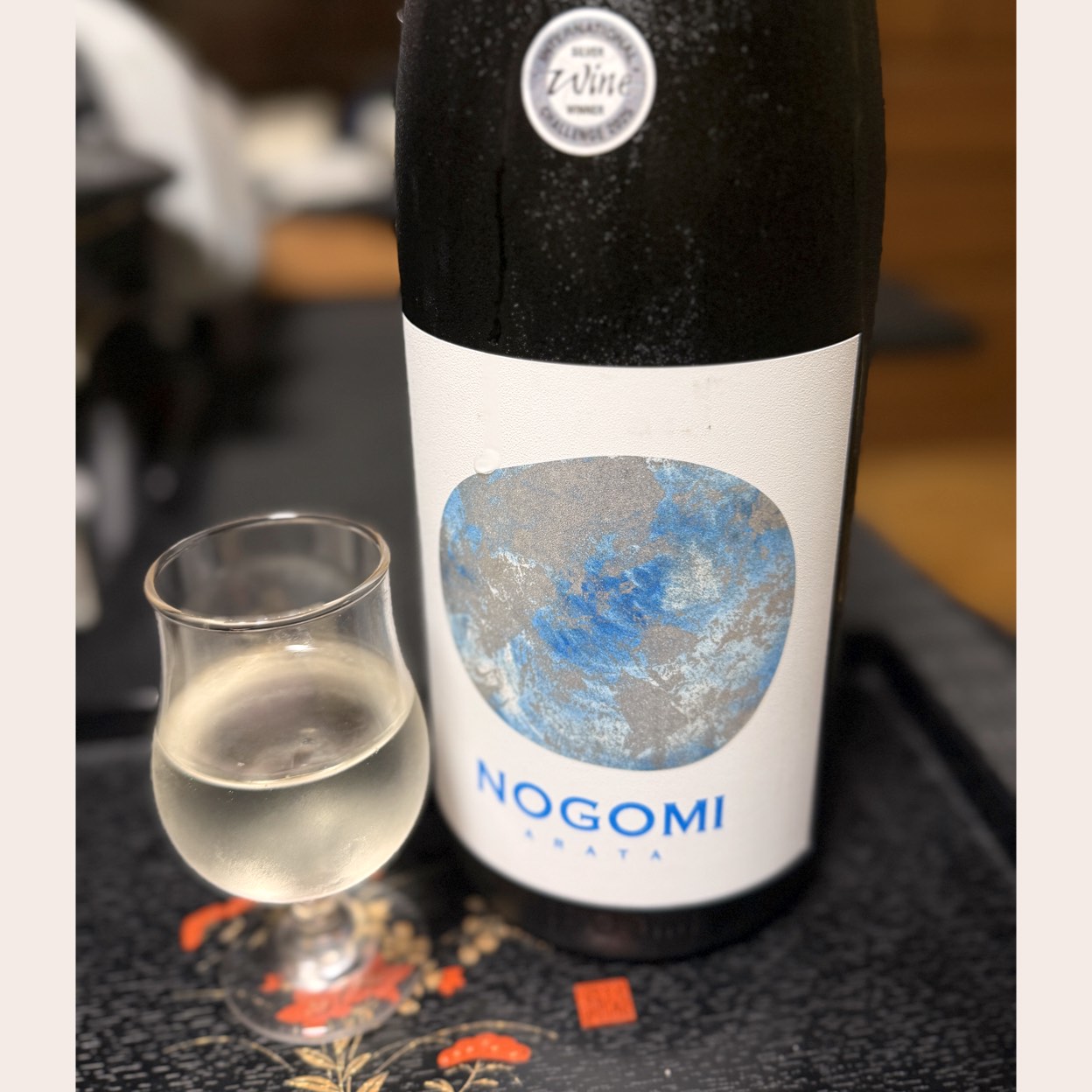 能古見酒造
純米大吟醸
NOGOMI ARATA

米　山田錦
精米歩合　50％
アルコール度数　14％　
日本酒度　－8
酸度　2.3 
「HPより」
　9代目が大学在学中に開発した酵母で醸して。酵母は、有明海から見つけ出され、リンゴ酸（爽やかな酸味）を多く産することが特徴。甘味と酸味の調和がとれた白ワインを思わせる　ラベルは京都西陣織の引箔をシールに活かし職人が手作業で描く模様に、2枚と同じものはない　新しい酵母、新しい酒質、新しい世代、新しいラベル、様々な新しさを表現✨

美旨✨