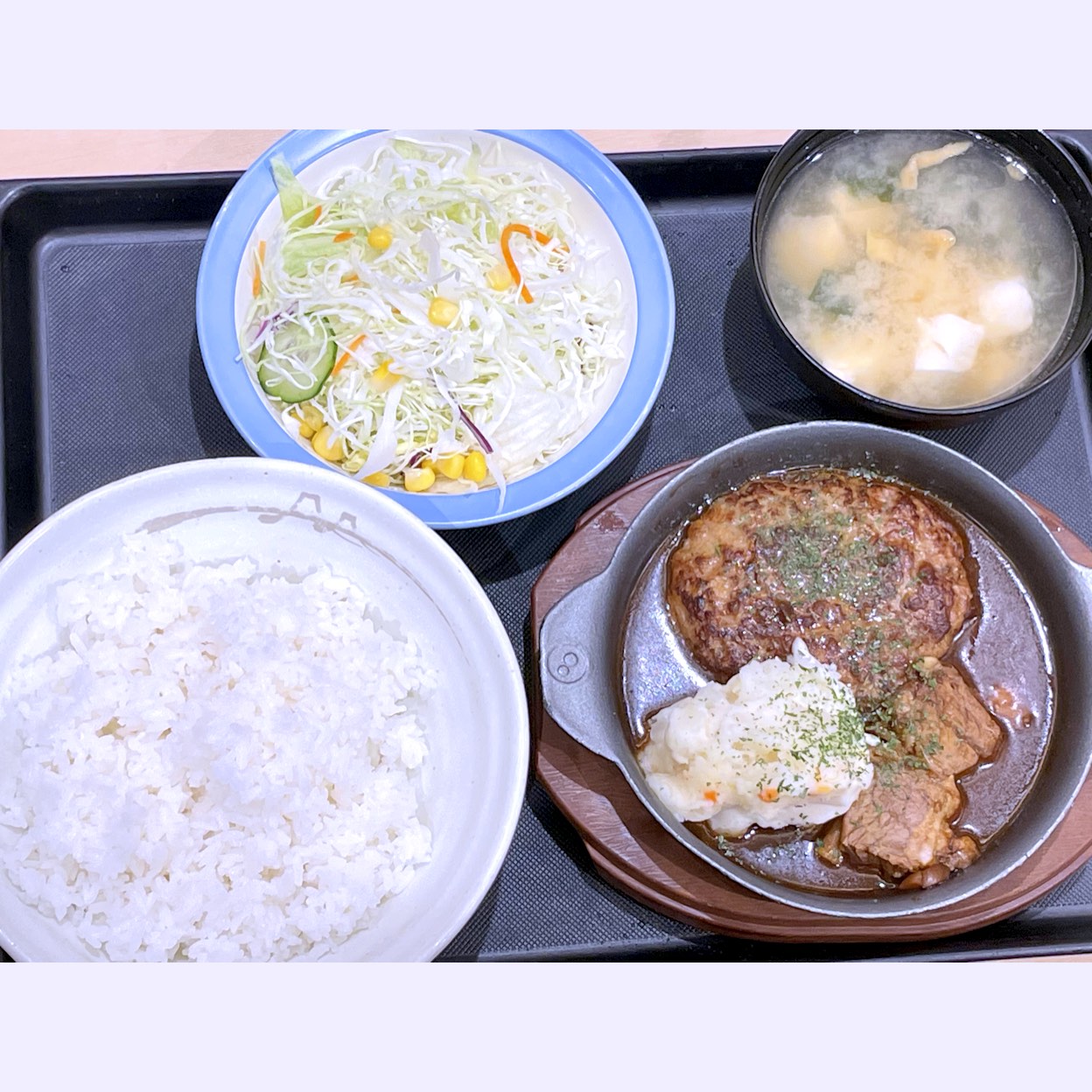 定食とどんぶりのチェーン店、松屋の期間限定メニュー、煮込みビーフシチューハンバーグ定食。赤ワイン仕立てのコク深い濃厚シチューソースにじっくり煮込んだとろっと牛肉とジューシーなハンバーグにポテトサラダを添えたメインに、御飯、サラダ、味噌汁がセットになった定食。味噌汁は50円追加して豆腐入りに変更した。量は少ないけど、濃厚なソースに肉とハンバーグがしっかりと染みてて美味かった。