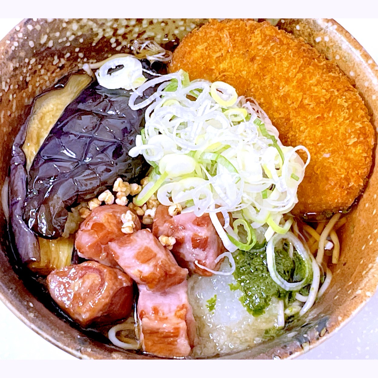 京急ロイヤルフーズ株式会社が運営する立ち食い饂飩(うどん)と蕎麦(そば)の店、えきめんやの期間限定メニュー、燻製鴨と揚げ茄子のぶっかけそばにコロッケ乗せ。
燻製された鴨肉、揚げ茄子、大根おろしと葱を乗せた蕎麦。饂飩か蕎麦から選ぶ事が出来る。蕎麦気分やったんでこちらにした。コロッケは別途購入して蕎麦にトッピングした。
雨で電車で通勤途中、折角京急川崎駅の改札内に入ったからたまには食べたくて乗る前に寄った。